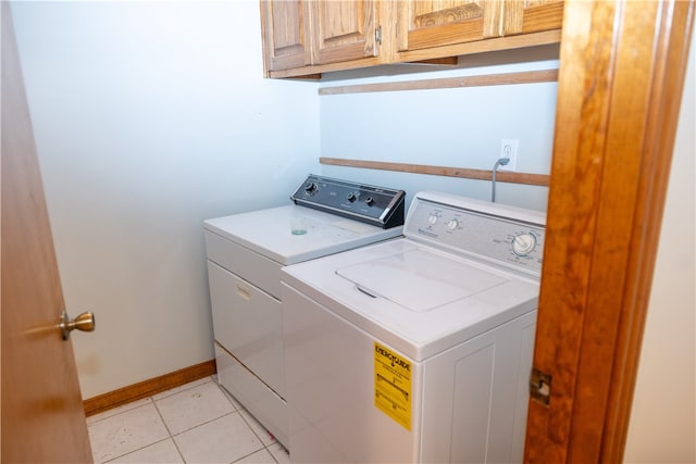 washroom featuring cabinets, washer and dryer, and light tile patterned floors