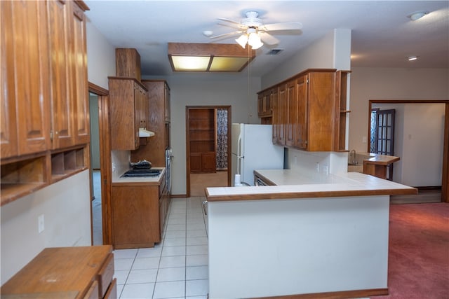 kitchen featuring light tile patterned flooring, ceiling fan, white refrigerator, and kitchen peninsula