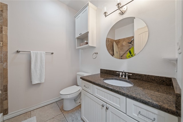 bathroom with a tile shower, vanity, tile patterned floors, and toilet