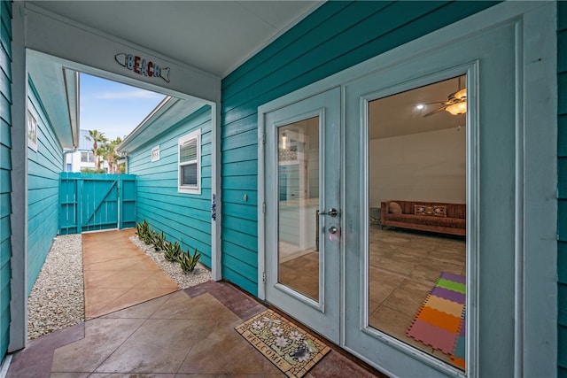 entryway with wood walls, ceiling fan, and tile patterned floors