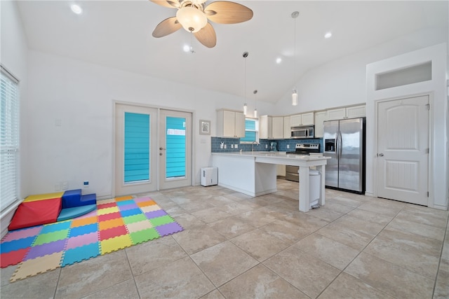 kitchen featuring appliances with stainless steel finishes, ceiling fan, a breakfast bar area, lofted ceiling, and pendant lighting