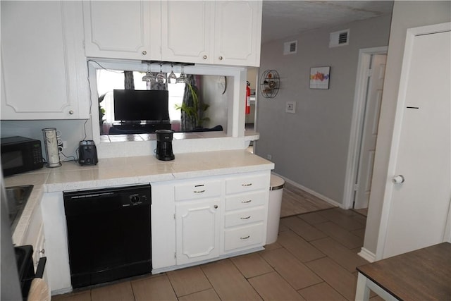 kitchen featuring light countertops, black appliances, and white cabinetry