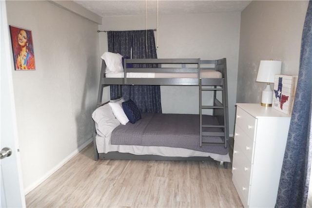 bedroom with light wood-type flooring and baseboards