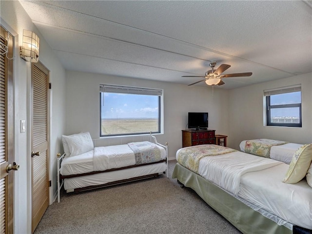 6109 State Highway 361 Unit 601, Port Aransas, TX 78373 - carpeted bedroom with baseboards, ceiling fan, and a textured ceiling