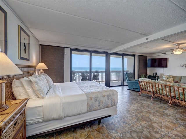 6109 State Highway 361 Unit 601, Port Aransas, TX 78373 - bedroom with access to exterior, a textured ceiling, beam ceiling, and stone finish floors