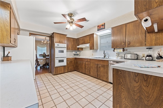 kitchen featuring white appliances, sink, ceiling fan with notable chandelier, and light tile patterned floors