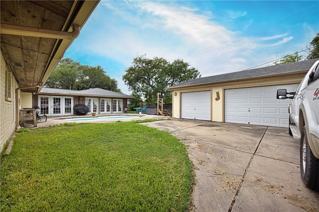 view of yard with french doors and a garage