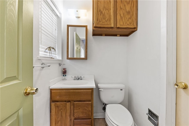 bathroom with a wealth of natural light, vanity, and toilet