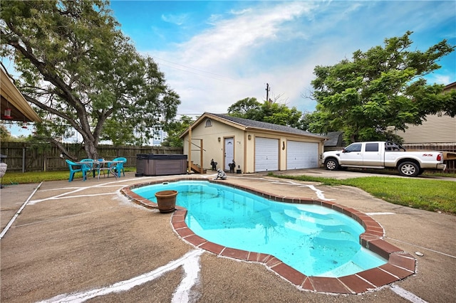 view of pool with a garage, a patio area, a hot tub, and an outdoor structure