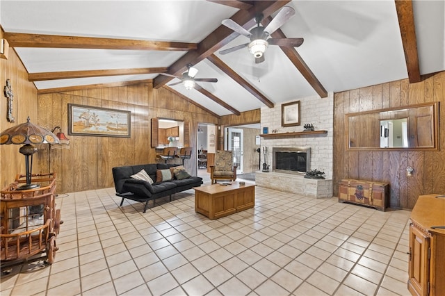 tiled living room featuring ceiling fan, a brick fireplace, wooden walls, and vaulted ceiling with beams