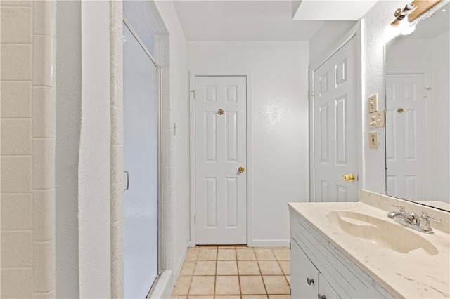 bathroom featuring vanity, a shower with door, and tile patterned flooring