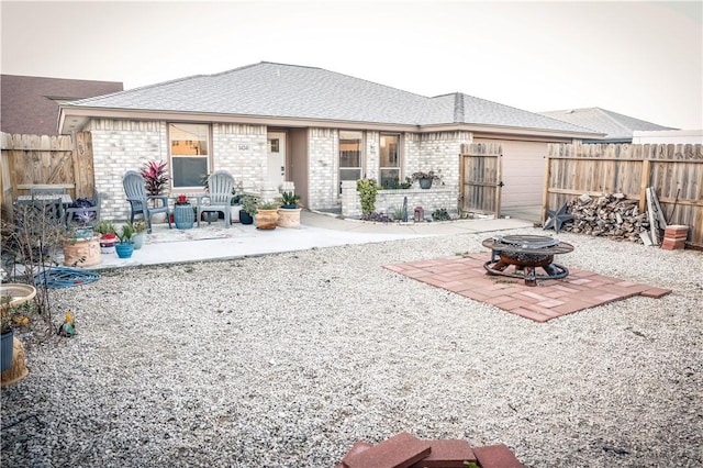 rear view of house with a patio and a fire pit