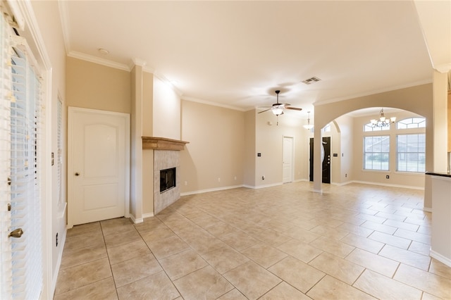 unfurnished living room with a tile fireplace, light tile patterned floors, ceiling fan with notable chandelier, and crown molding