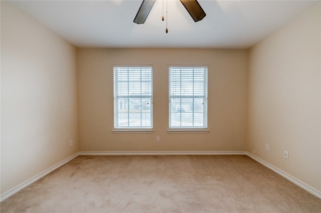 carpeted spare room featuring ceiling fan