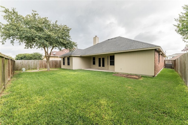 back of house featuring a lawn and a patio