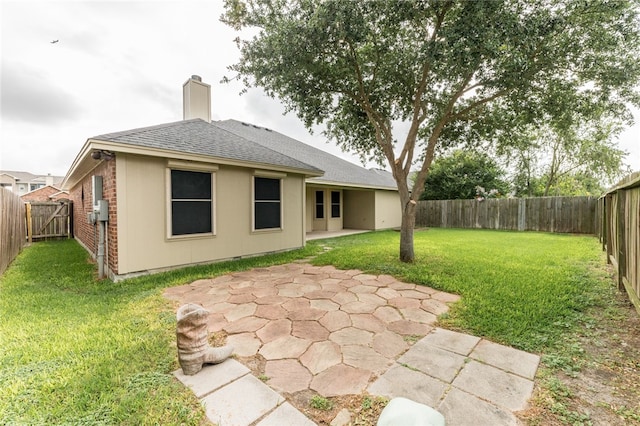 rear view of house featuring a patio and a lawn