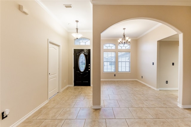 tiled entryway featuring a chandelier and ornamental molding