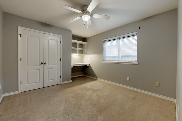 unfurnished bedroom featuring ceiling fan, a closet, and light colored carpet