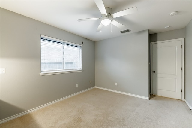 carpeted spare room with ceiling fan