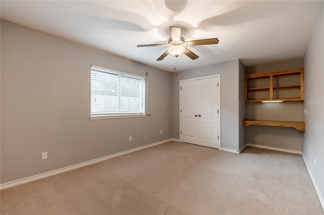 unfurnished bedroom featuring ceiling fan, light colored carpet, and a closet