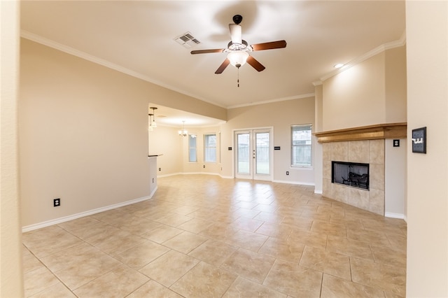 unfurnished living room featuring ceiling fan with notable chandelier, ornamental molding, and a tiled fireplace