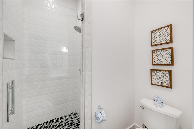bathroom with a shower stall and toilet