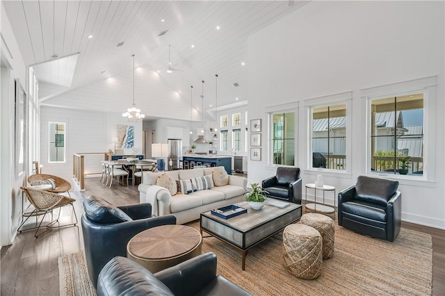 living room featuring wood finished floors, a chandelier, and high vaulted ceiling