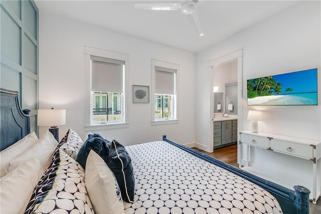 bedroom featuring wood finished floors, ensuite bath, and a ceiling fan