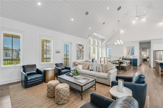 living room with light wood finished floors, lofted ceiling, wood ceiling, a chandelier, and plenty of natural light