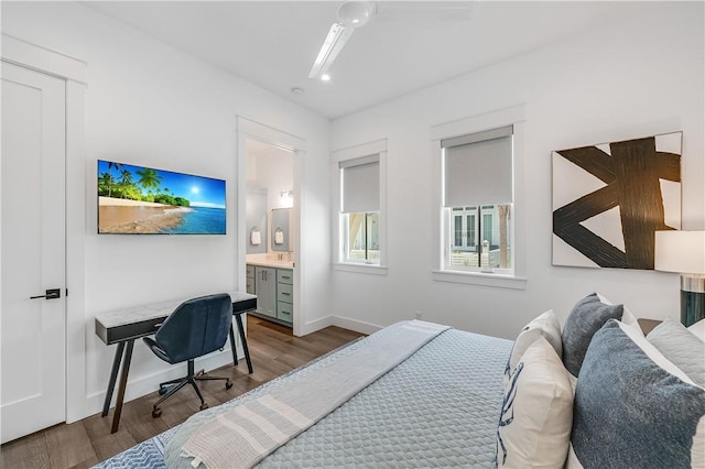 bedroom with wood finished floors, baseboards, connected bathroom, and an office area