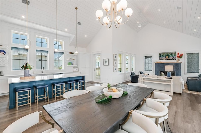 dining area featuring high vaulted ceiling, dark wood-type flooring, healthy amount of natural light, recessed lighting, and a chandelier