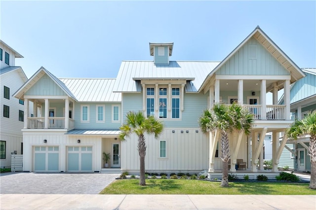 view of front of home with a standing seam roof, decorative driveway, board and batten siding, and metal roof