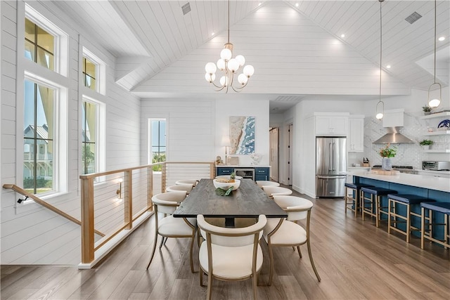 dining area with healthy amount of natural light, wooden ceiling, a chandelier, wood finished floors, and vaulted ceiling
