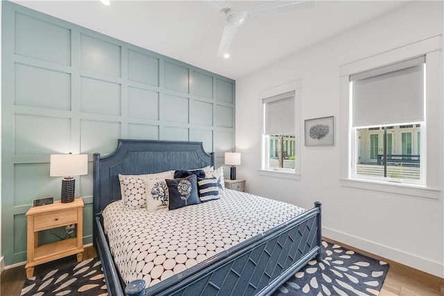 bedroom with baseboards, wood finished floors, and recessed lighting