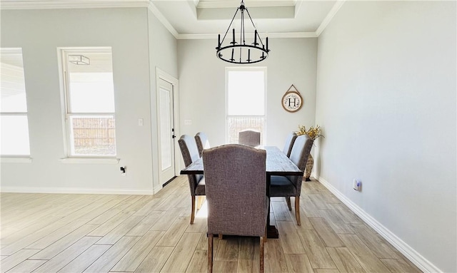 dining room featuring ornamental molding, a chandelier, and a tray ceiling