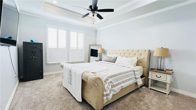 carpeted bedroom with crown molding, ceiling fan, and a tray ceiling