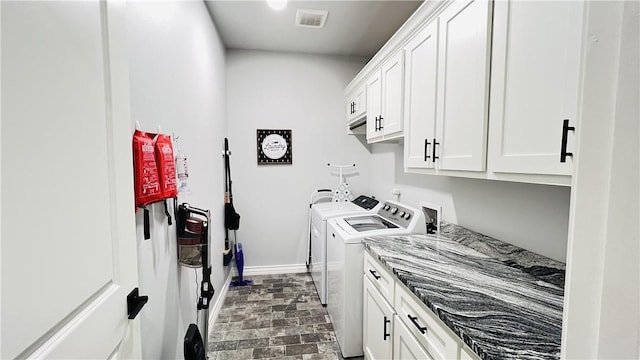 laundry area featuring independent washer and dryer and cabinets