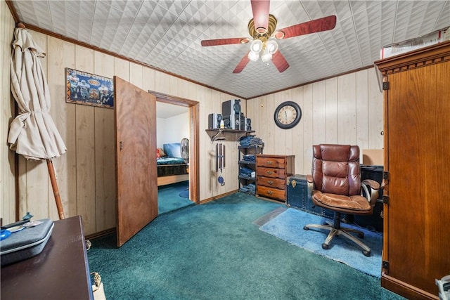 carpeted office with ceiling fan, wooden walls, and ornamental molding