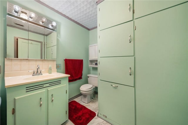 bathroom with vanity, toilet, and tasteful backsplash