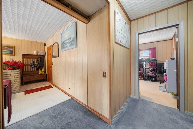 corridor with carpet, vaulted ceiling with beams, and wooden walls