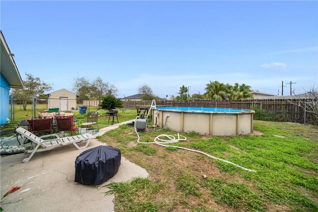 view of yard featuring a fenced in pool, a shed, and a patio