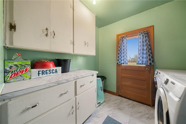 clothes washing area with washer and dryer and cabinets