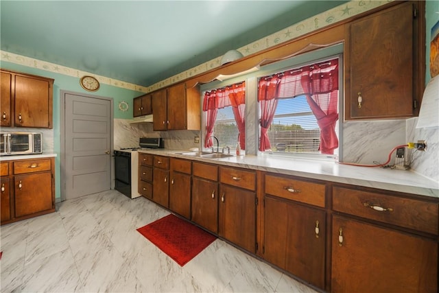 kitchen with backsplash, range with electric stovetop, and sink