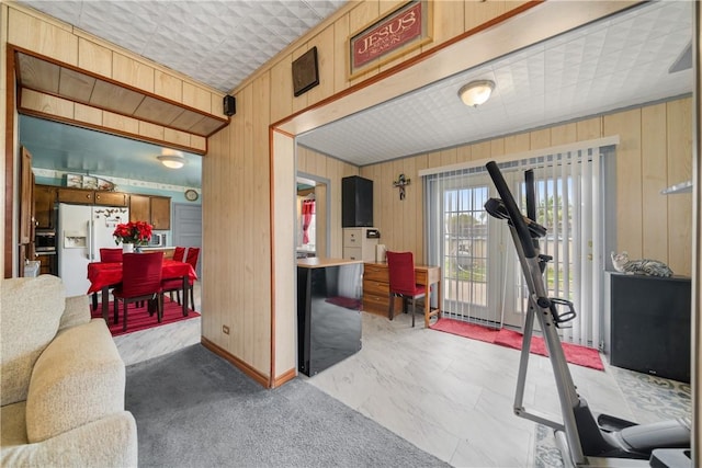 living room with wood walls and light colored carpet