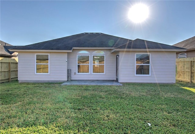 back of property with a lawn and a patio