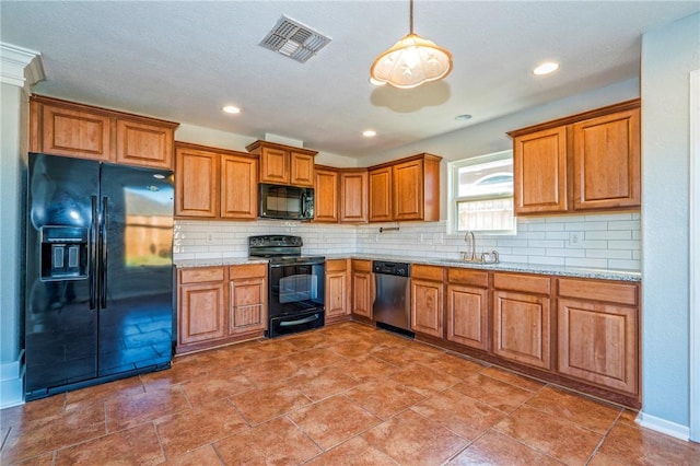 kitchen with sink, tasteful backsplash, black appliances, light stone countertops, and decorative light fixtures