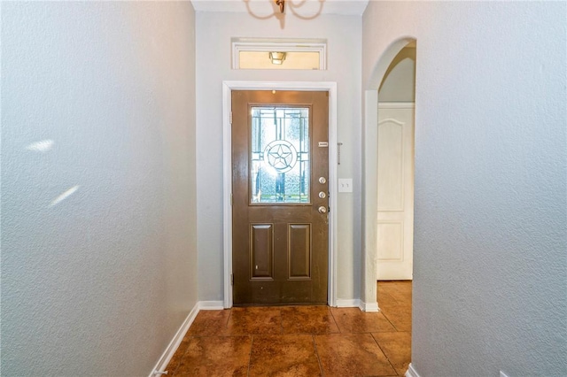 doorway with dark tile patterned floors