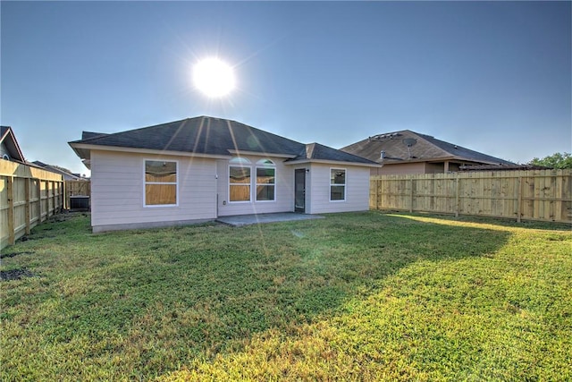 back of property featuring central AC unit and a lawn