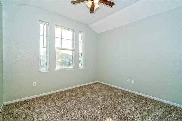 carpeted empty room featuring vaulted ceiling and ceiling fan