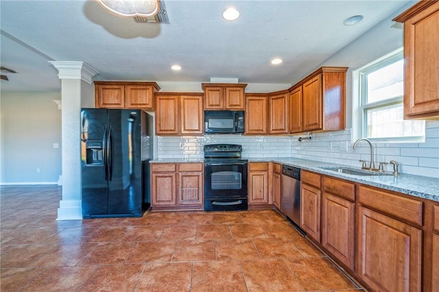 kitchen featuring light stone counters, sink, backsplash, and black appliances